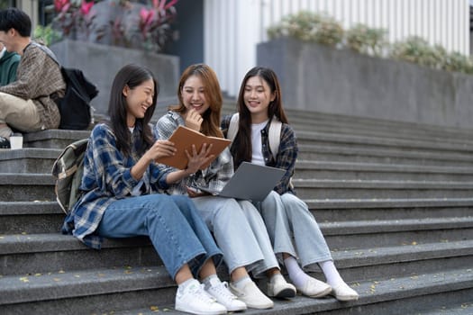 Group of Asian college student reading books and tutoring special class for exam on grass field at outdoors. Happiness and Education learning concept. Back to school concept. Teen and people theme...