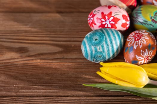 Many Easter eggs in different patterns and colors form a composition for Easter. The entire Christmas decoration seen from above.