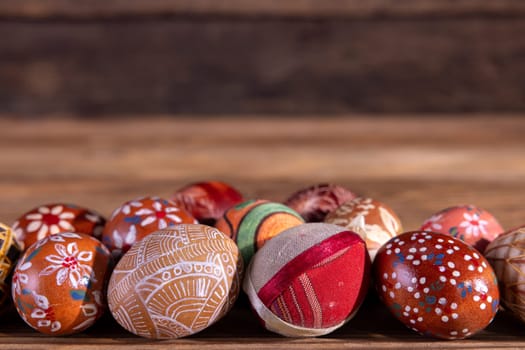 A close-up view of the Easter eggs arranged in a single line, kept in the brown color scheme with space for your own artwork or Easter inscription.