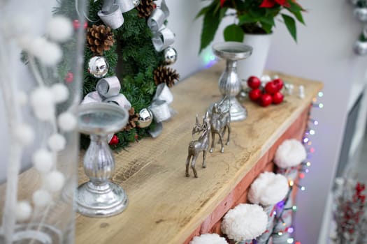 Christmas decoration on fireplace made of bricks. Fireplace with wooden board and winter socks.
