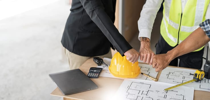 Civil engineer teams meeting working together wear worker helmets hardhat on construction site in modern city. Foreman industry project manager engineer teamwork. Asian industry professional team..