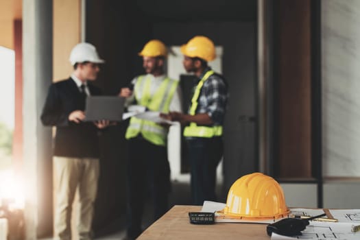 Civil engineer teams meeting working together wear worker helmets hardhat on construction site in modern city. Foreman industry project manager engineer teamwork. Asian industry professional team...