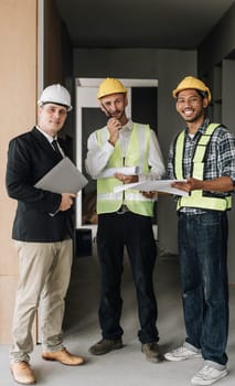 Civil engineer teams meeting working together wear worker helmets hardhat on construction site in modern city. Foreman industry project manager engineer teamwork. Asian industry professional team...