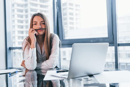 Have fun at break. Young woman in white formal clothes is indoors in the modern office.