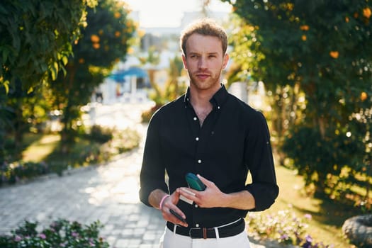 Young man is outdoors at sunny daytime. Concept of vacation.
