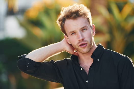 Young man is outdoors at sunny daytime. Concept of vacation.