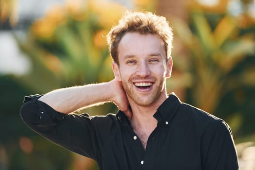 Young man is outdoors at sunny daytime. Concept of vacation.