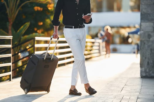 Young man is outdoors at sunny daytime. Concept of vacation.