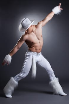 Sexy dancer in cowboy costume. Studio portrait