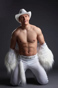 Dancer in white cowboy costume. Studio portrait