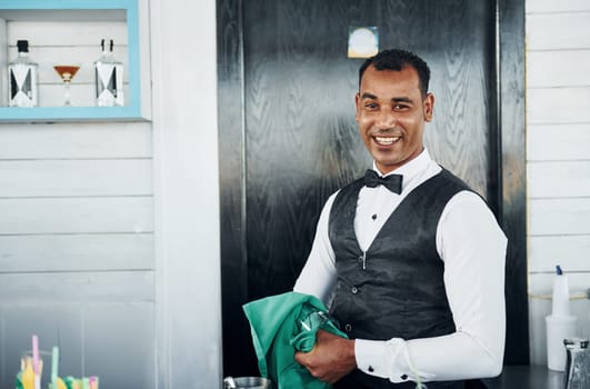 Black waiter in formal clothes is at his work outdoors at sunny daytime.