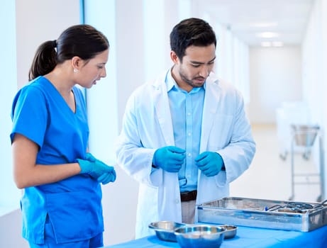 Preparing for the next patient. a dentist speaking about equipment with his assistant