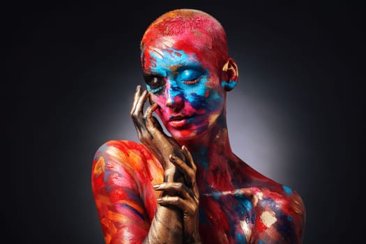 Step into my art world. an attractive young woman posing alone in the studio with paint on her face and body