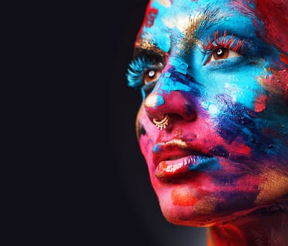 I live for creativity. an attractive young woman posing alone in the studio with paint on her face