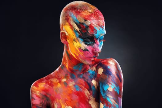 I choose to live in colour. an attractive young woman posing alone in the studio with paint on her face and body