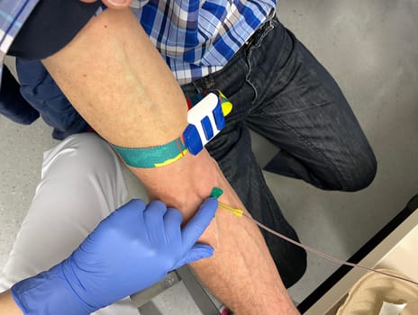 a nurse, doctor or medical technologist in blue gloves taking a blood sample from a patient in a hospital. High quality photo