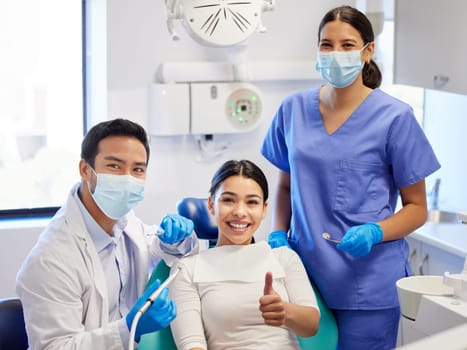 Nothing says good job like a great smile. Portrait of a young woman showing thumbs up while visiting the dentist