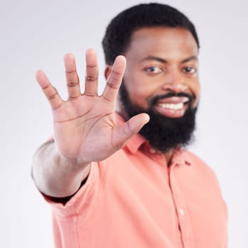Black man, hand sign and stop in studio portrait with smile, icon and communication by background. Young african model, signal or symbol for opinion, protest palm and warning with confident choice.