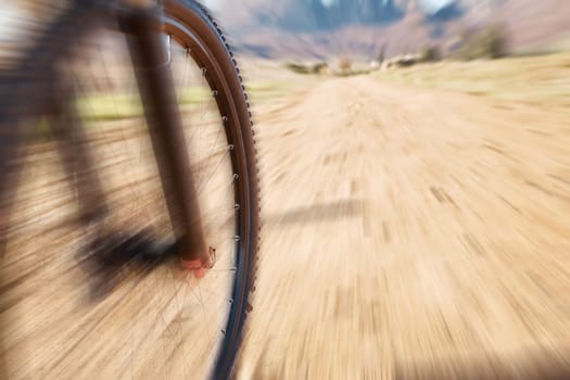 Cycling wheel, motion blur and fitness in nature, countryside and training of triathlon, sports and power. Closeup bicycle, speed and outdoor adventure for off road freedom, bike exercise and action.