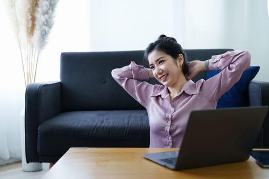 Portrait of a self-employed Asian woman using a computer at home.