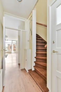 a hallway in a house with stairs leading up to the first floor and an open door that leads to another room