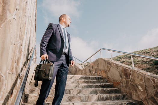 Business executive with briefcase going down the stairs.