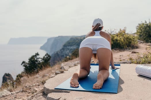 Fitness woman sea. Outdoor workout with fitness rubber bands in park over beach. Female fitness pilates yoga routine concept. Healthy lifestyle. Happy fit woman exercising with rubber band in park