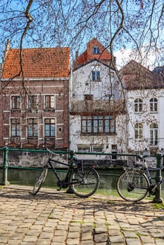 Parked bikes along a canal in the medieval city of Ghent in the Flemish region of Belgium. Travel concept. High quality photo