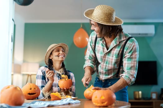 Welcome to our patch. a young couple carving pumpkins at home