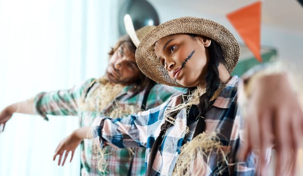 Keep calm and scare on. a young couple dressed in halloween costumes being being playful at home