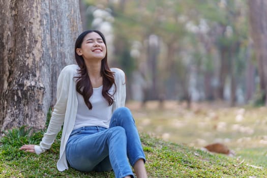 Cheerful overjoyed woman happy and enjoying peaceful beautiful in park, looking up with broad smile.