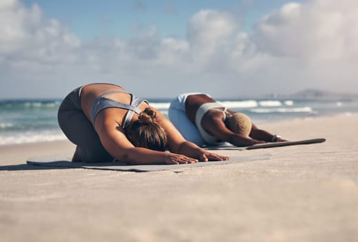 Yoga is one type of medicine thatll solve all your problems. two young women practicing yoga on the beach
