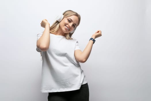 joyful woman with big wireless headphones in studio.