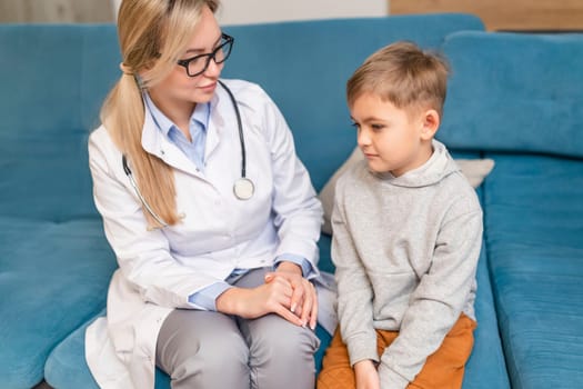 A family doctor examines a little boy at home. Pediatrician girl treats a child.