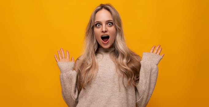 pleasantly surprised young woman over isolated yellow background.