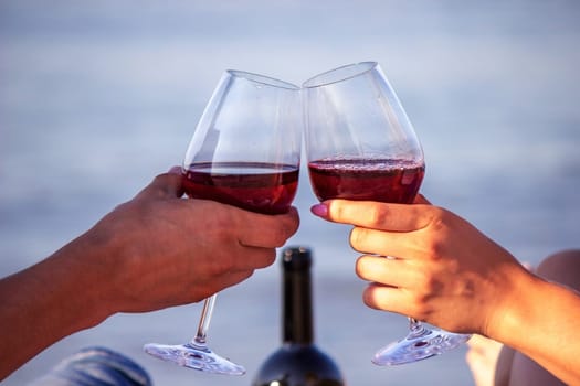 Romantic couple enjoying wine by the sea. Selective focus