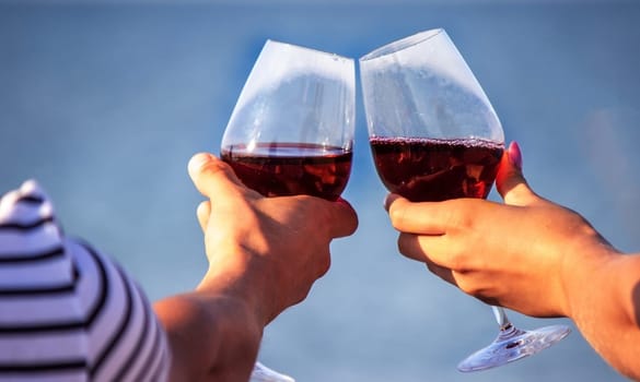 Romantic couple enjoying wine by the sea. Selective focus