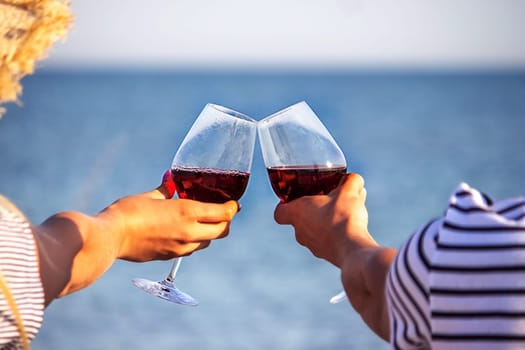 Romantic couple enjoying wine by the sea. Selective focus