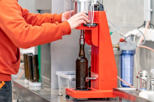 capping beer bottles in a brewery.