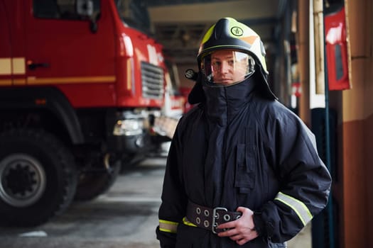 Male firefighter in protective uniform standing near truck.