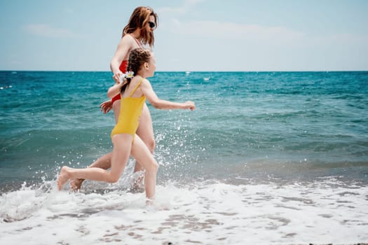 Happy loving family mother and daughter having fun together on the beach. Mum playing with her kid in holiday vacation next to the ocean - Family lifestyle and love concept.