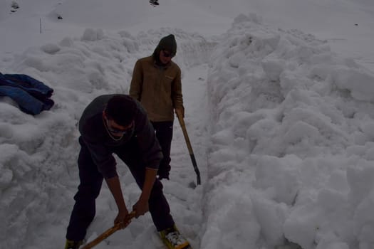 Rudarprayag, Uttarakhand, India, April 26 2014, laborer opening the snow-covered Kedarnath temple route. Kedarnath is a town in the Indian state of Uttarakhand and has gained importance because of Kedarnath Temple.