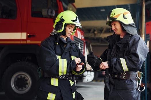 Male and female firefighters in protective uniform standing together.
