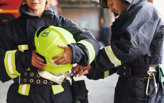 Male and female firefighters in protective uniform standing together.