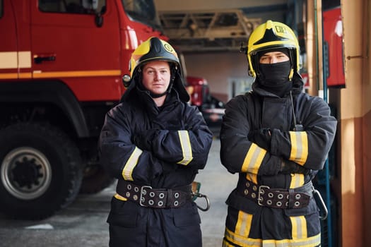 Male and female firefighters in protective uniform standing together.