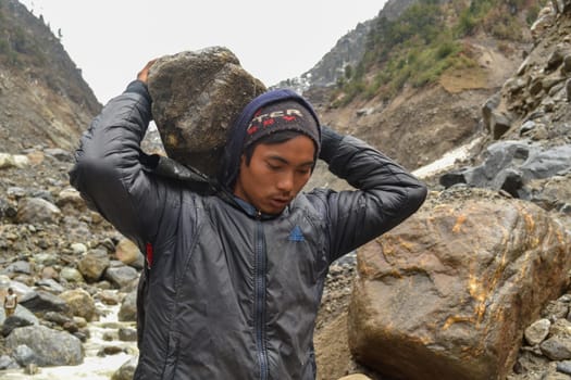 Rudarprayag, Uttarakhand, India, April 26 2014, A labor man taking stone for Kedarnath reconstruction. Kedarnath temple is located in the Himalayas, approximately 11,000 feet above sea level, that faced devastating disaster in 2013.