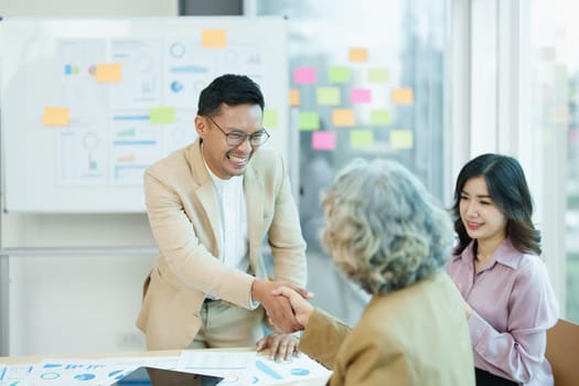 Asian entrepreneurs handshakes to congratulate the agreement between the two companies to enhance investment and financial strength. deal concept.