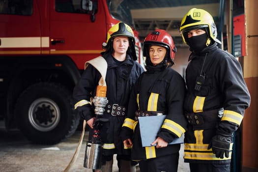 Posing for a camera. Group of firefighters in protective uniform that is on station.