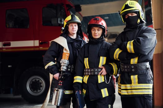 Posing for a camera. Group of firefighters in protective uniform that is on station.