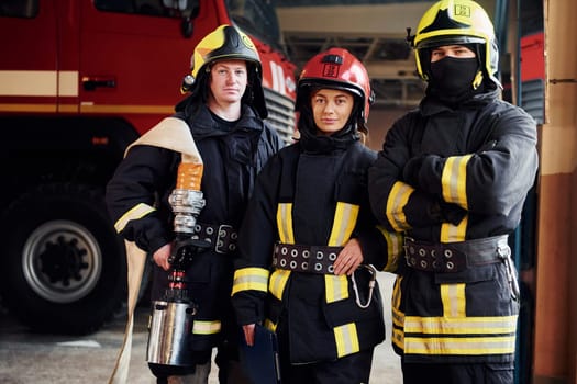 Posing for a camera. Group of firefighters in protective uniform that is on station.